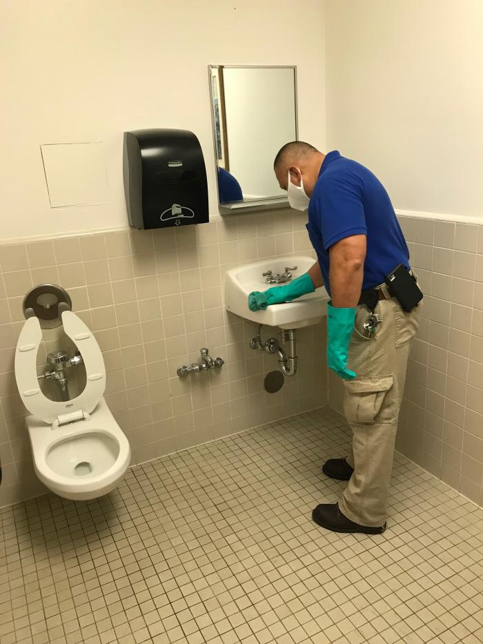 person cleaning bathroom
