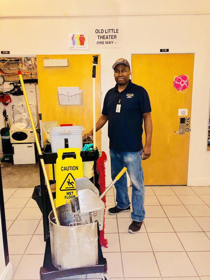 person standing next to cleaning cart