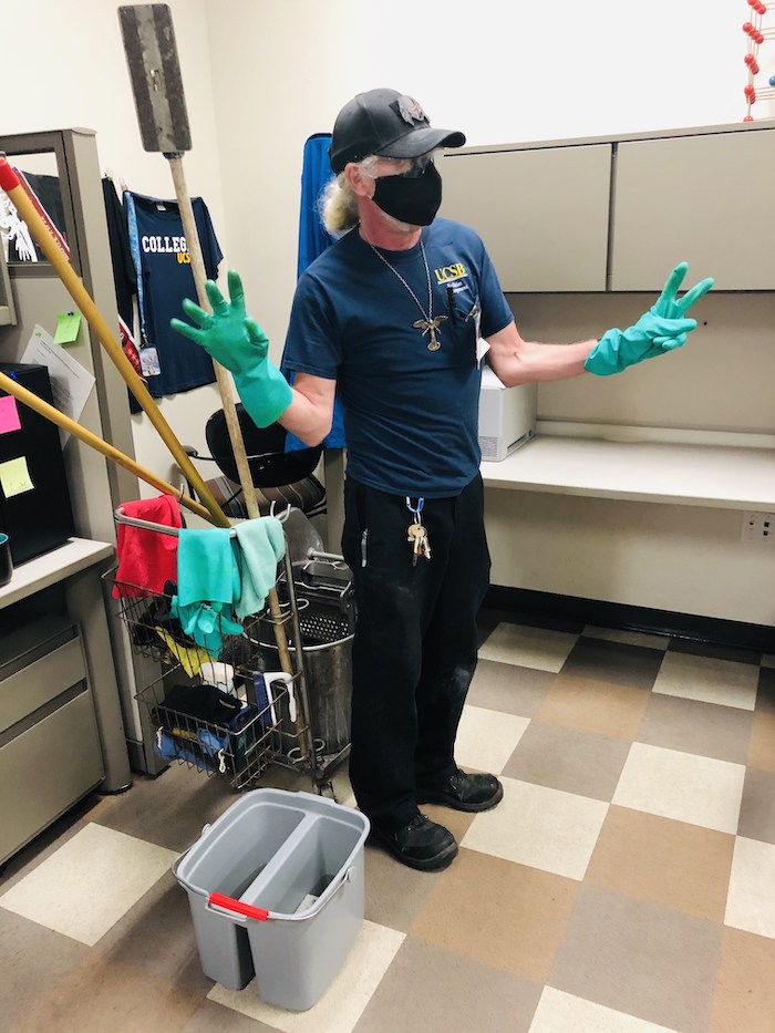 person posing next to cleaning cart