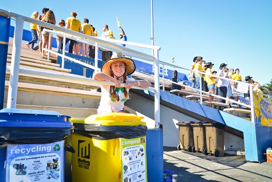 woman sitting behind trash bins at UCSB's Harder Stadium